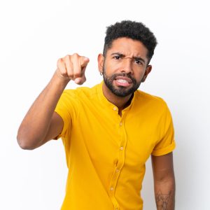 Young Brazilian man isolated on white background frustrated and pointing to the front